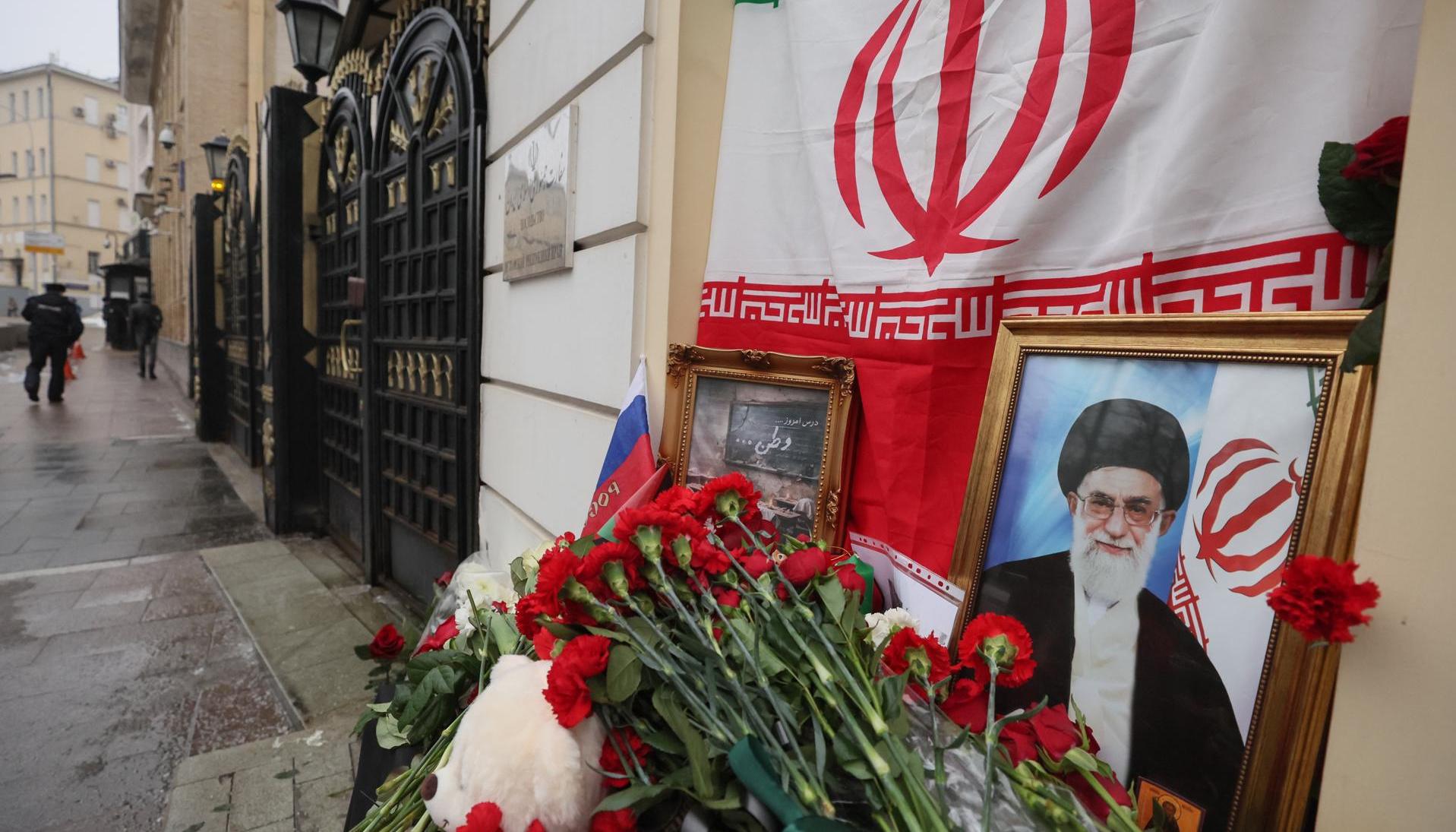 Flores y juguetes son colocados al lado del retrato del líder supremo de Irán, el ayatolá Ali Jameneí. 