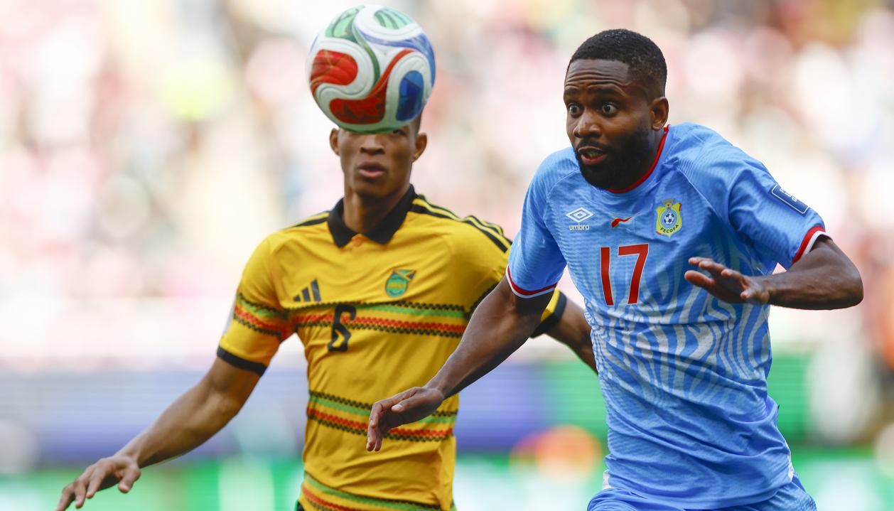 El congolés Cedric Bakambu disputa la pelota con el jamaiquino Richard King.