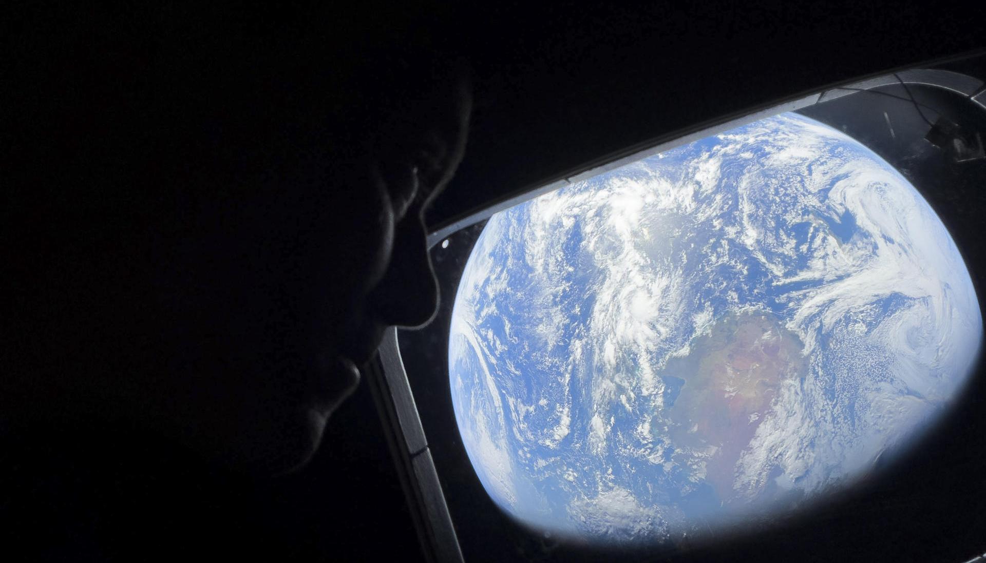 El comandante Reid Wiseman observa la Tierra mientras continúan adentrándose en el espacio hacia la Luna.