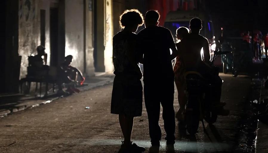 Personas hablan en una calle durante un apagón.