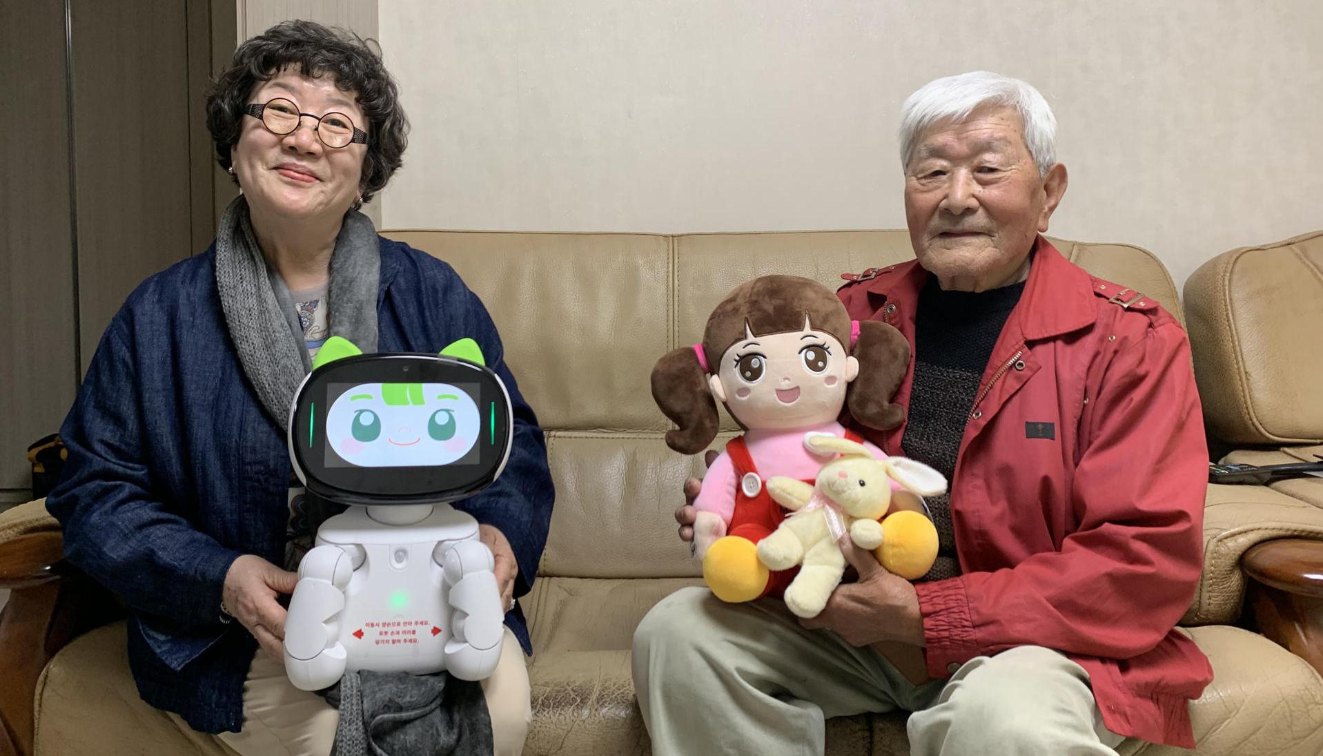 Lee Ha-seon y An Sang-ik sosteniendo el robot Dasomi y la muñeca Chorongi. 