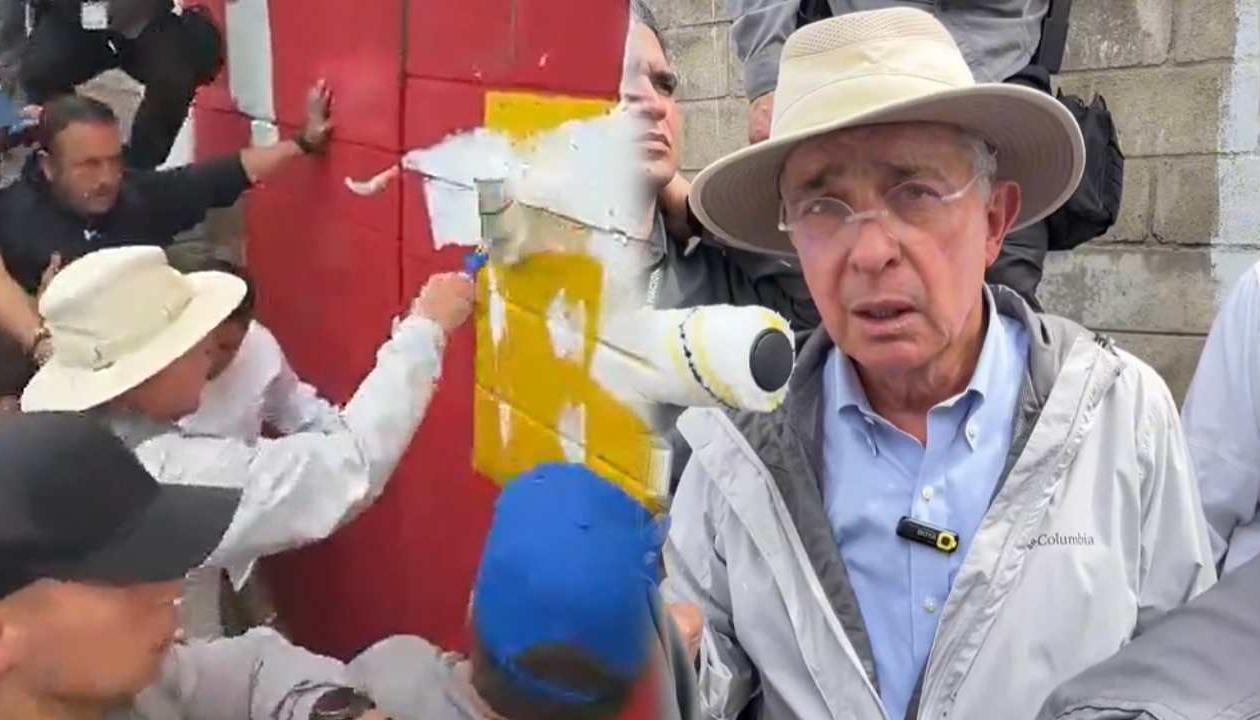 El expresidente Álvaro Uribe pintando sobre el mural.