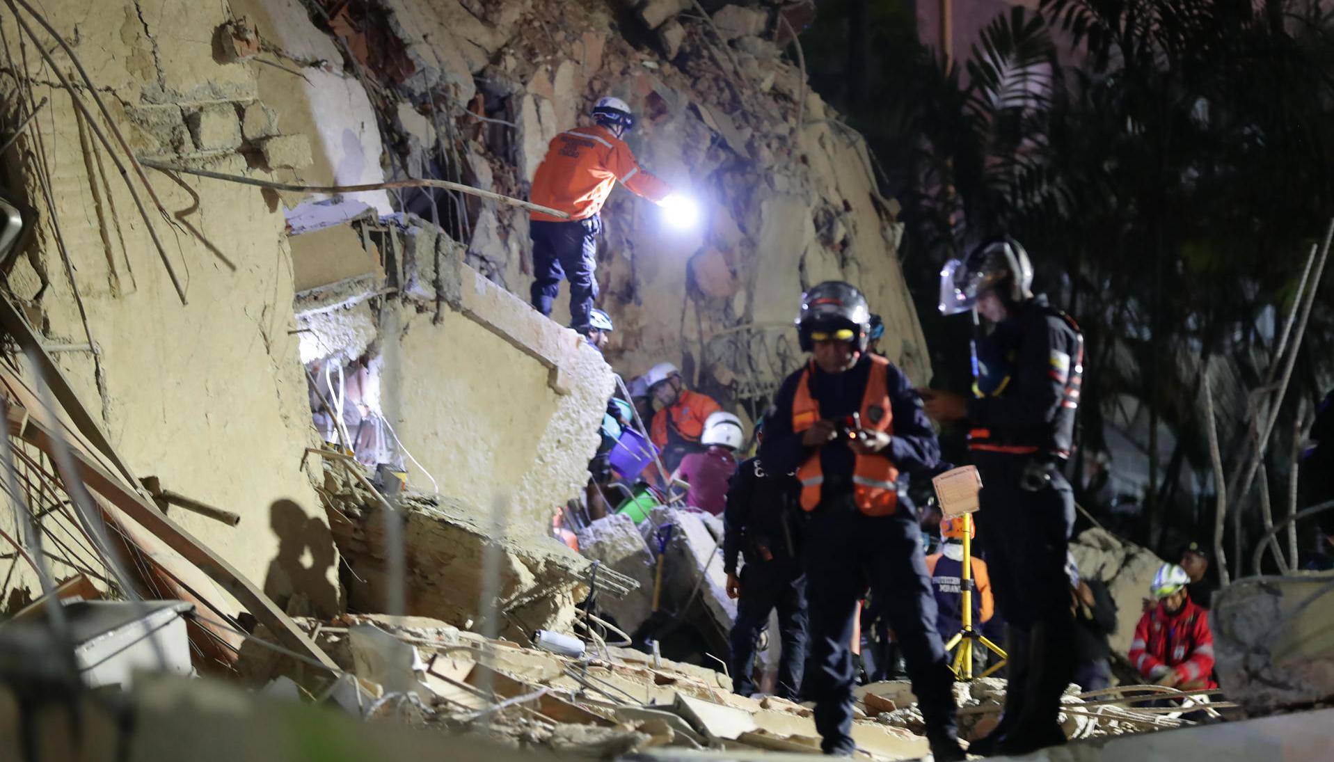 Integrantes de cuerpos de emergencia buscan víctimas.