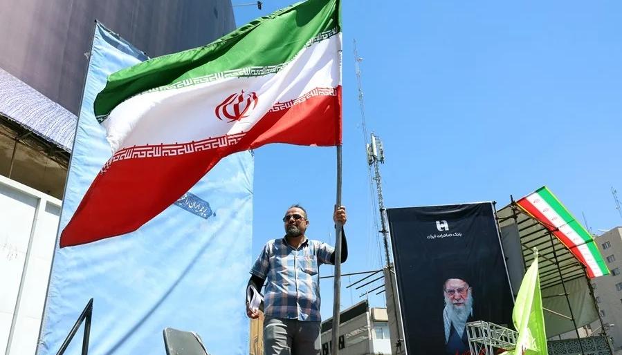 Un iraní sosteniendo una bandera de su país, en la Plaza Valiasr, en Teherán.