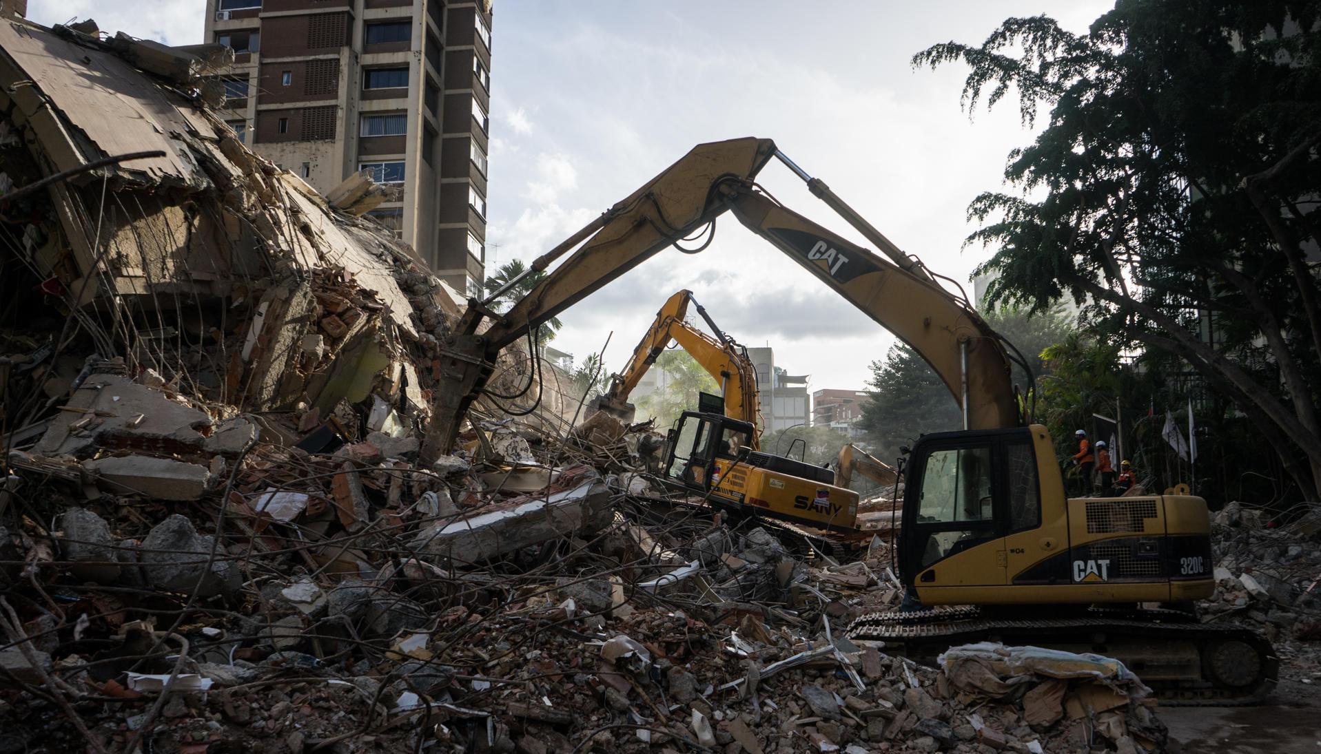 Integrantes de equipos de rescate trabajan en un edificio afectado.