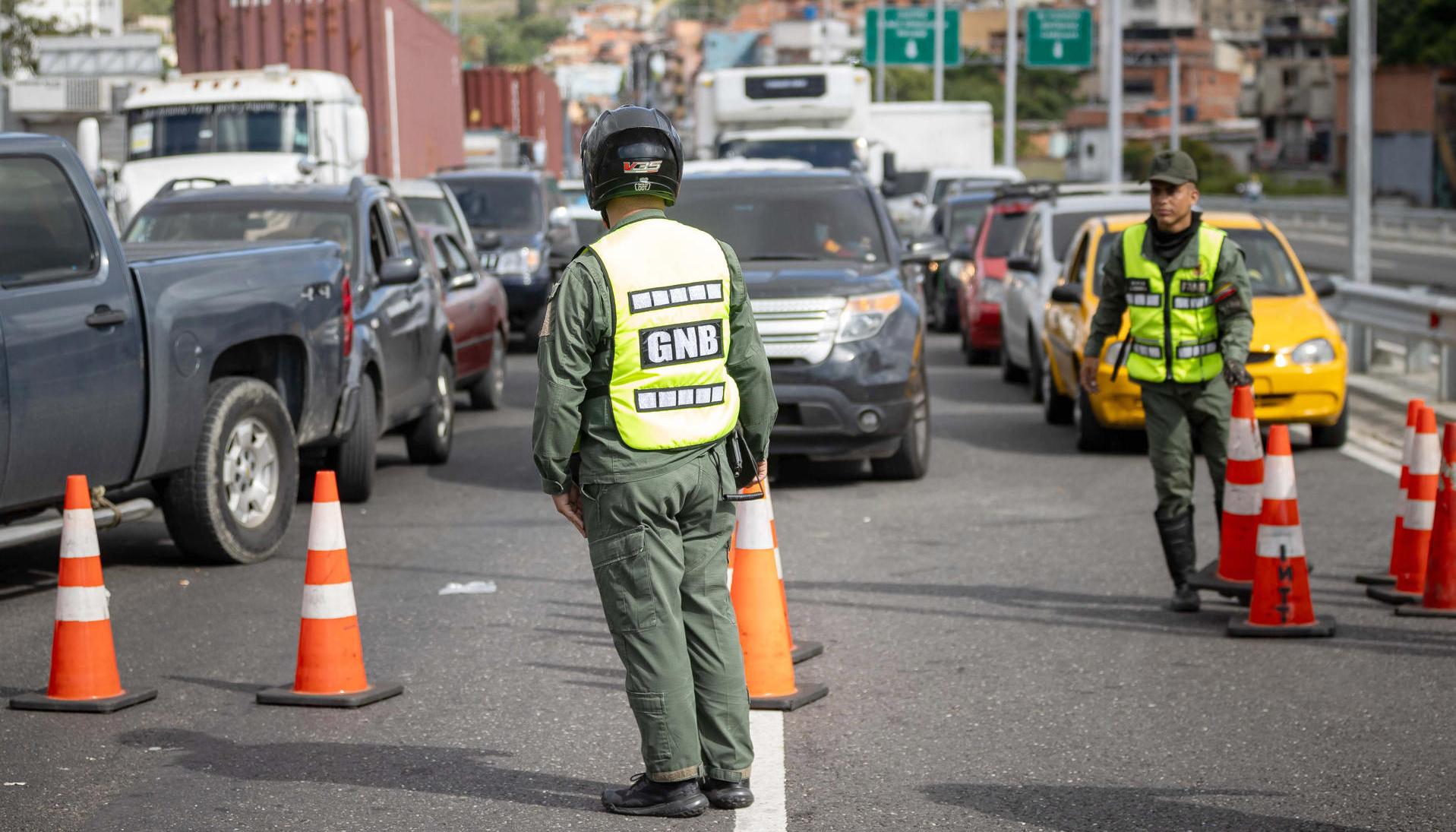 Integrantes de la Guardia Nacional Bolivariana custodian en la autopista bloqueada que conecta al estado La Guaira con Caracas.