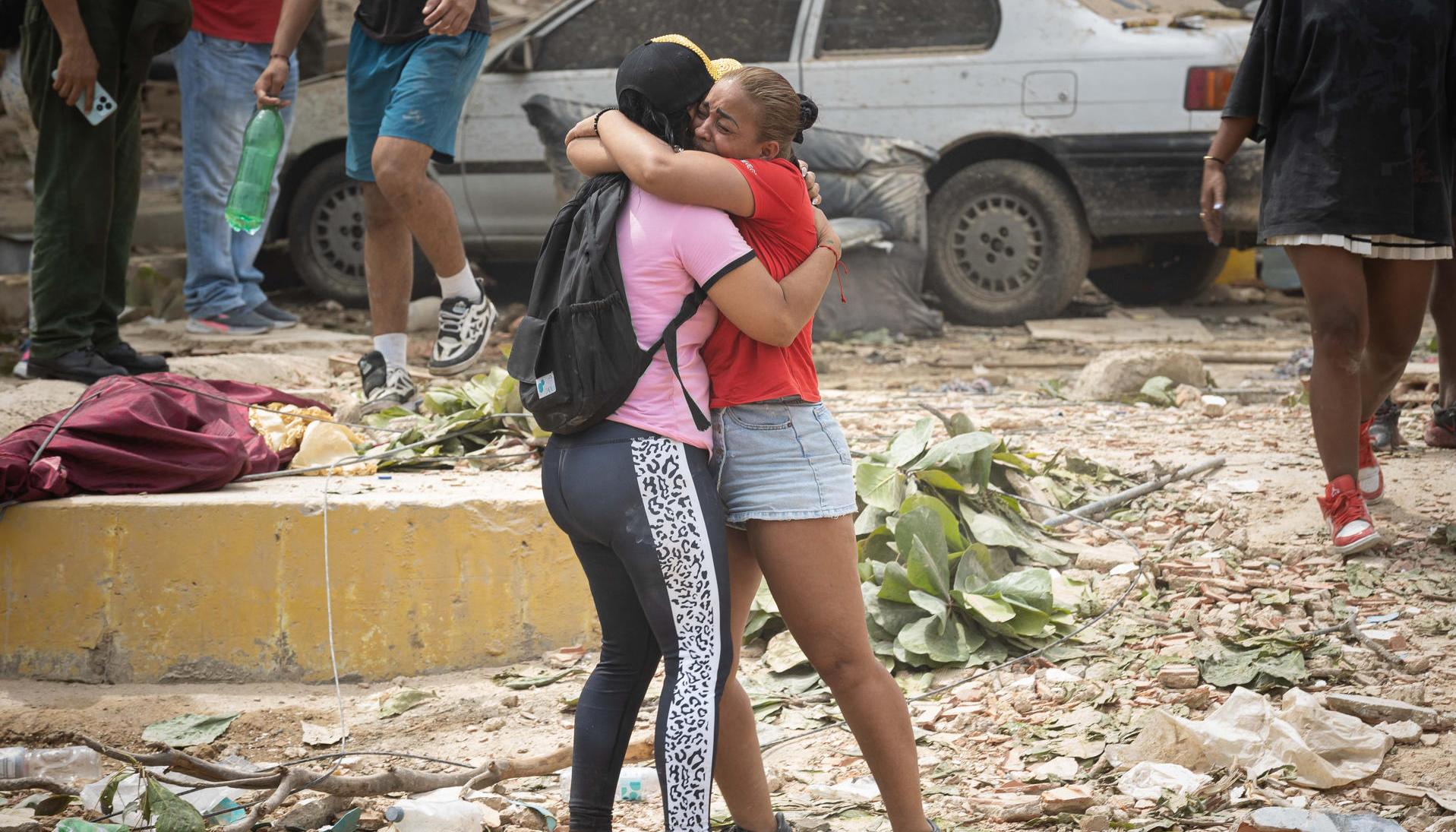Personas lloran frente a escombros de edificios afectados por los terremotos 