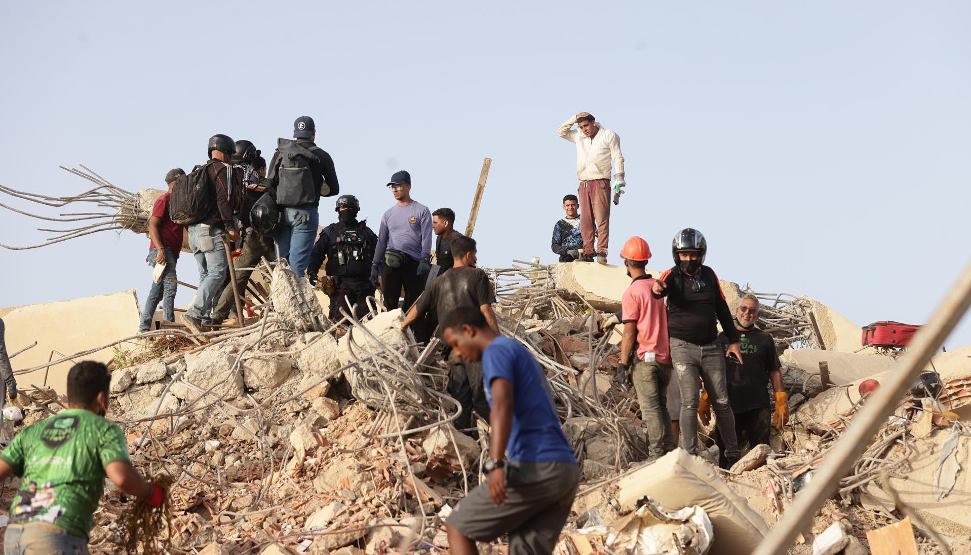 Personas realizan labores de búsqueda en una zona afectada por los terremotos, en La Guaira.