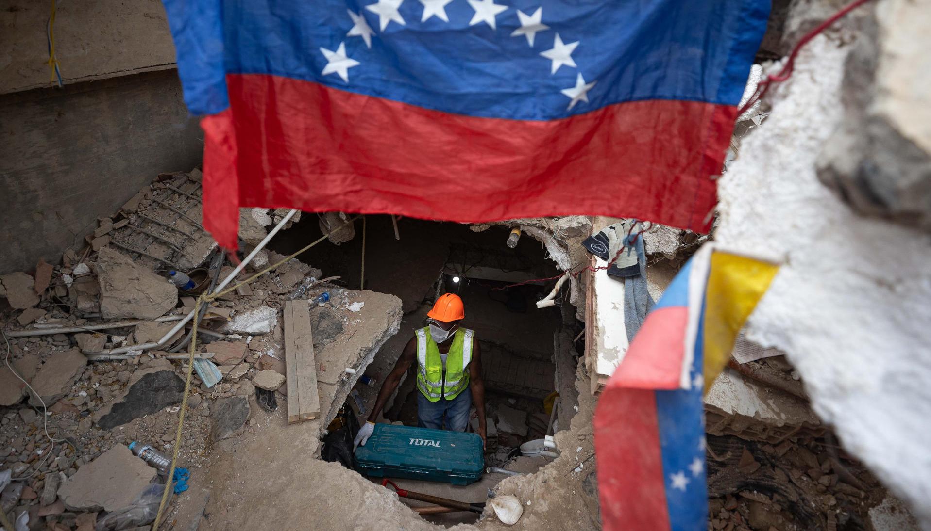 Una persona realiza labores de búsqueda entre los escombros de edificios destruidos por terremotos en La Guaira. 