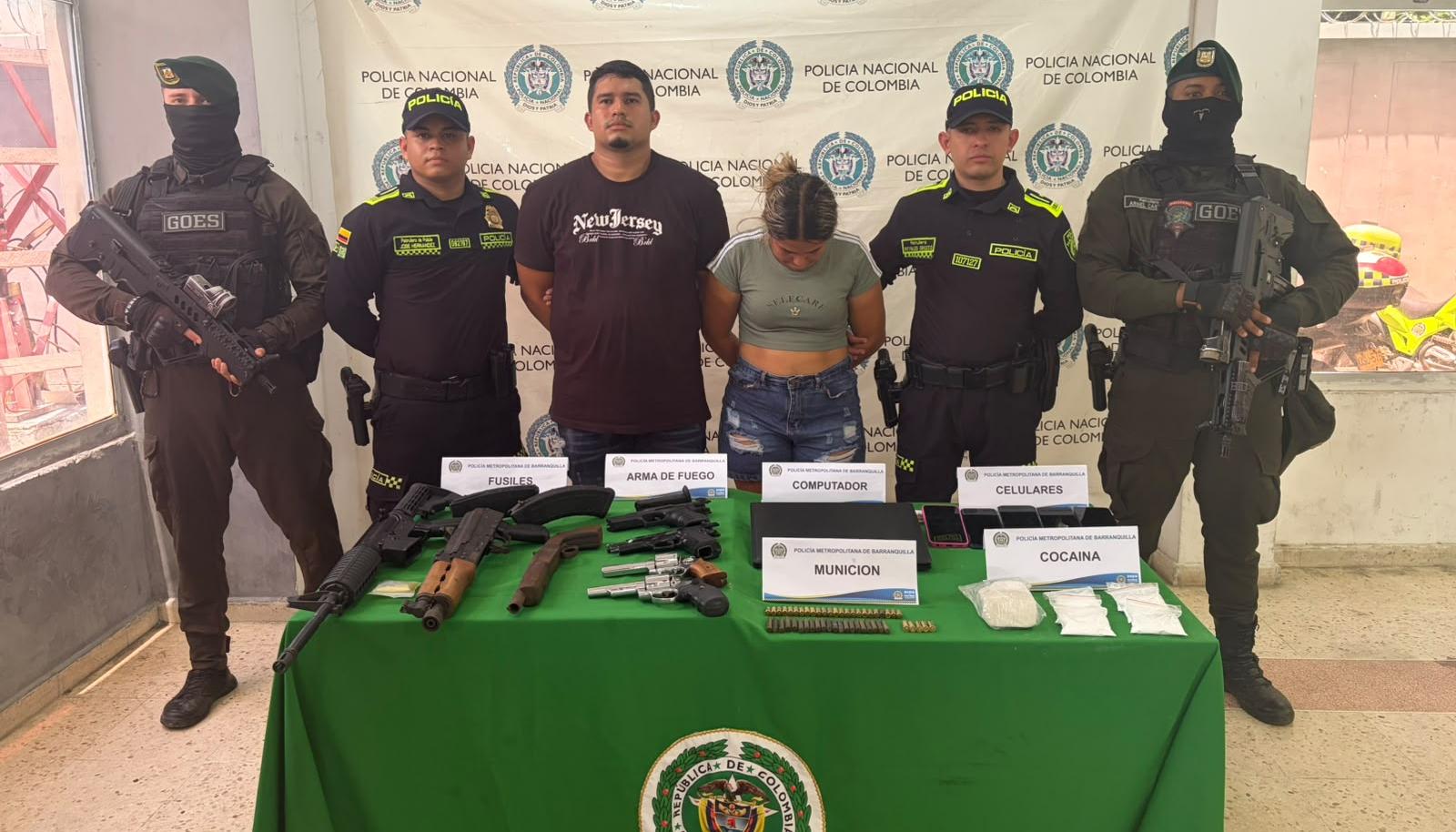 La pareja capturada junto con el arsenal de guerra incautado. 