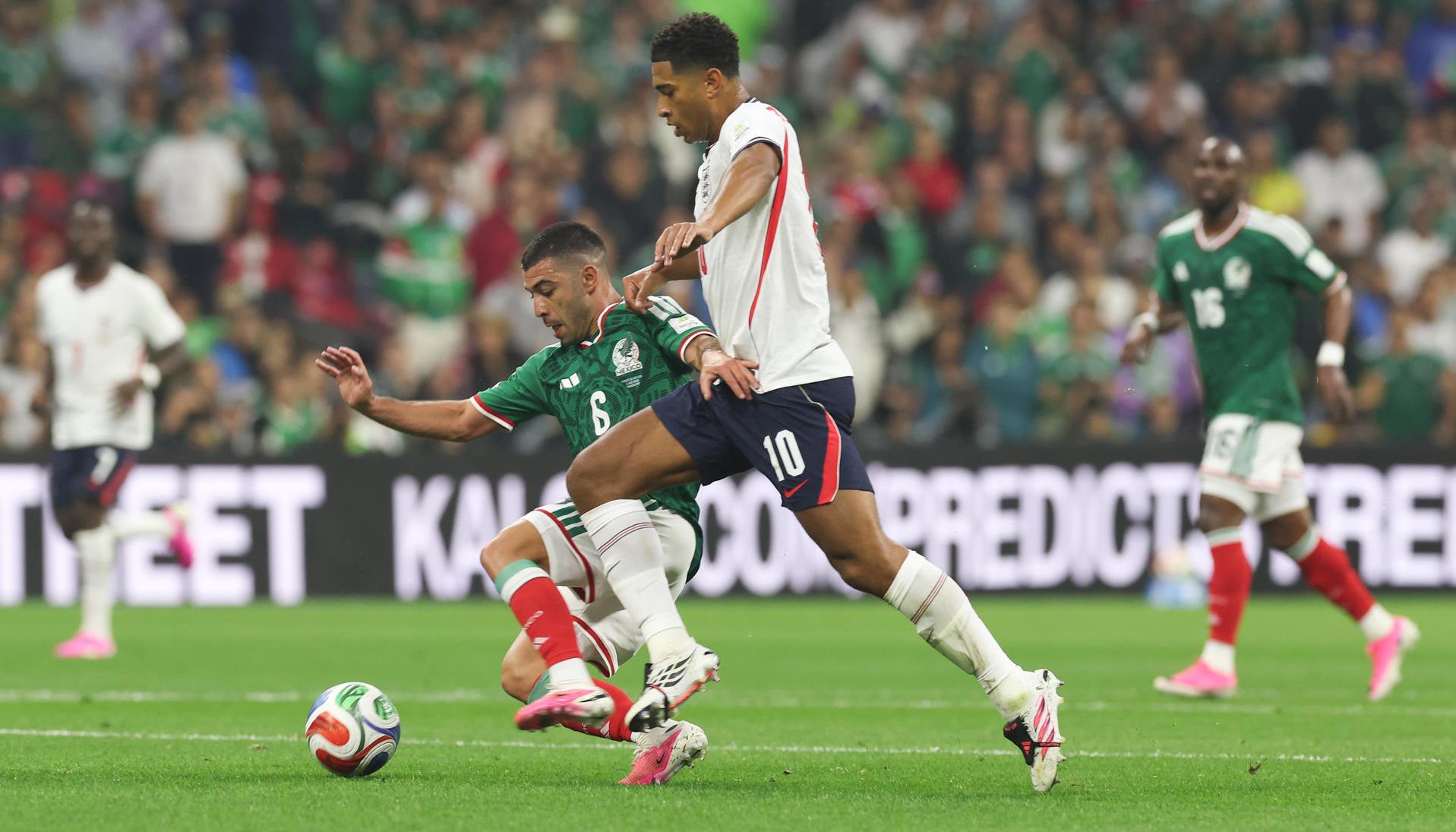  Erik Lira (i) de México disputa un balón con Jude Bellingham de Inglaterra
