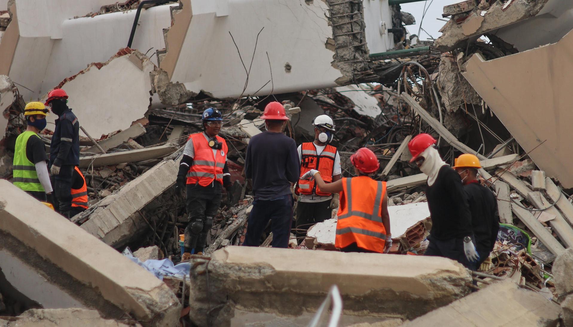 Voluntarios en una edificación destruida por los terremotos.