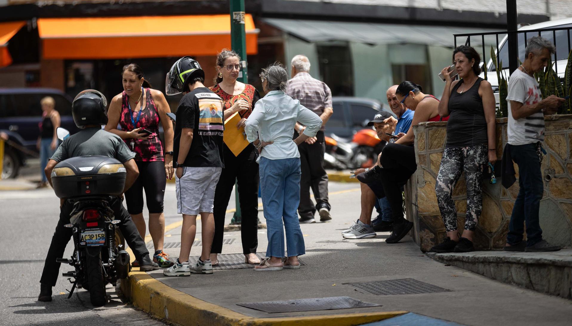 Personas esperan afuera de sus viviendas este viernes. 