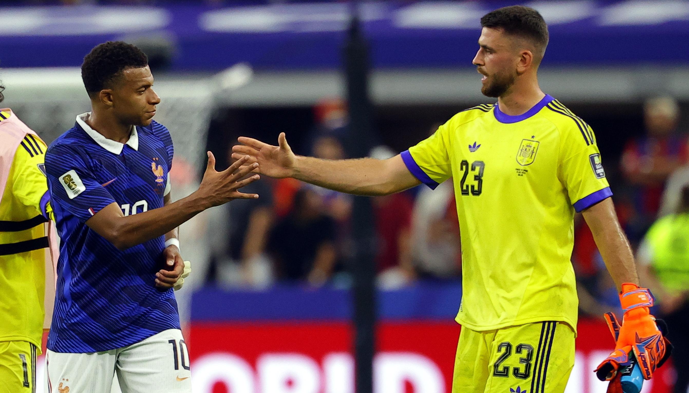 Kylian Mbappé se saluda con el portero español Unai Simón.