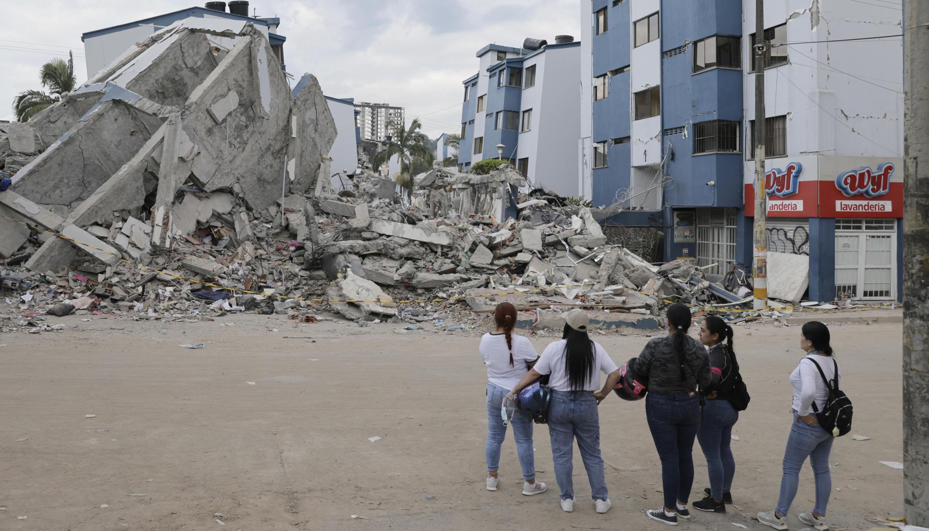 Personas observan los escombros de un edificio afectado por el terremoto en Pereira. 