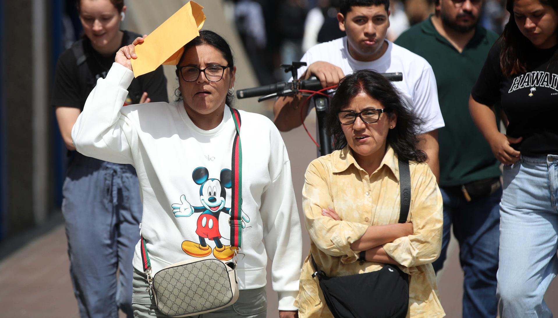 Personas caminan por una calle durante una jornada de altas temperaturas.