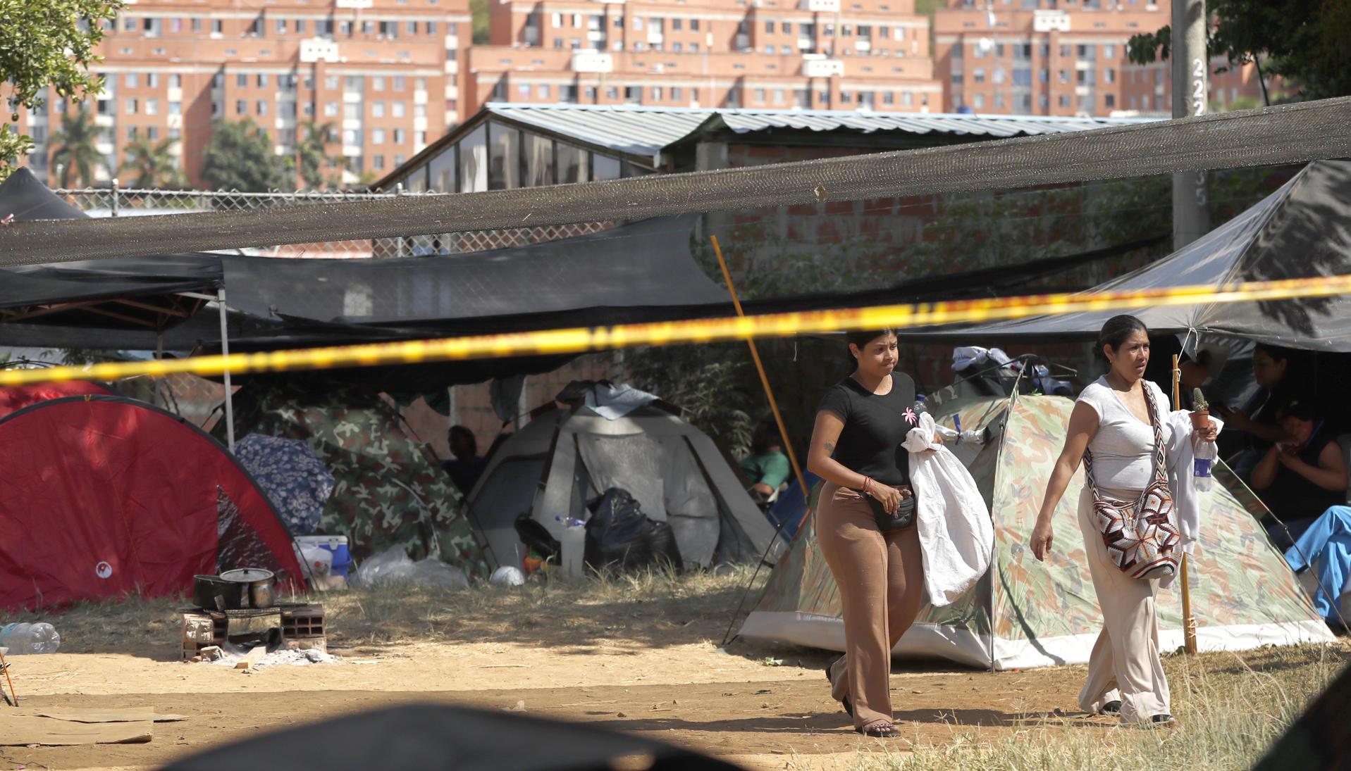Personas esperan en carpas este jueves, junto al edificio Reserva de Meléndez, en Cali.