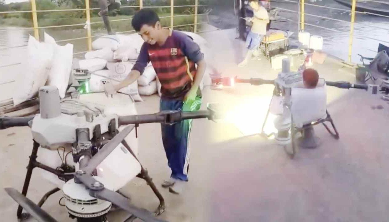 Joven sobre el dron aspersor.