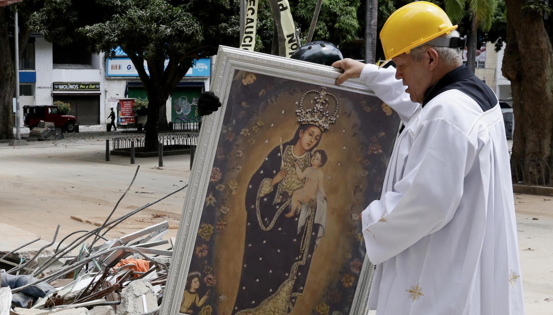 El padre Nelson Giraldo Mejía sostiene una réplica de la Virgen de Nuestra Señora de la Pobreza.