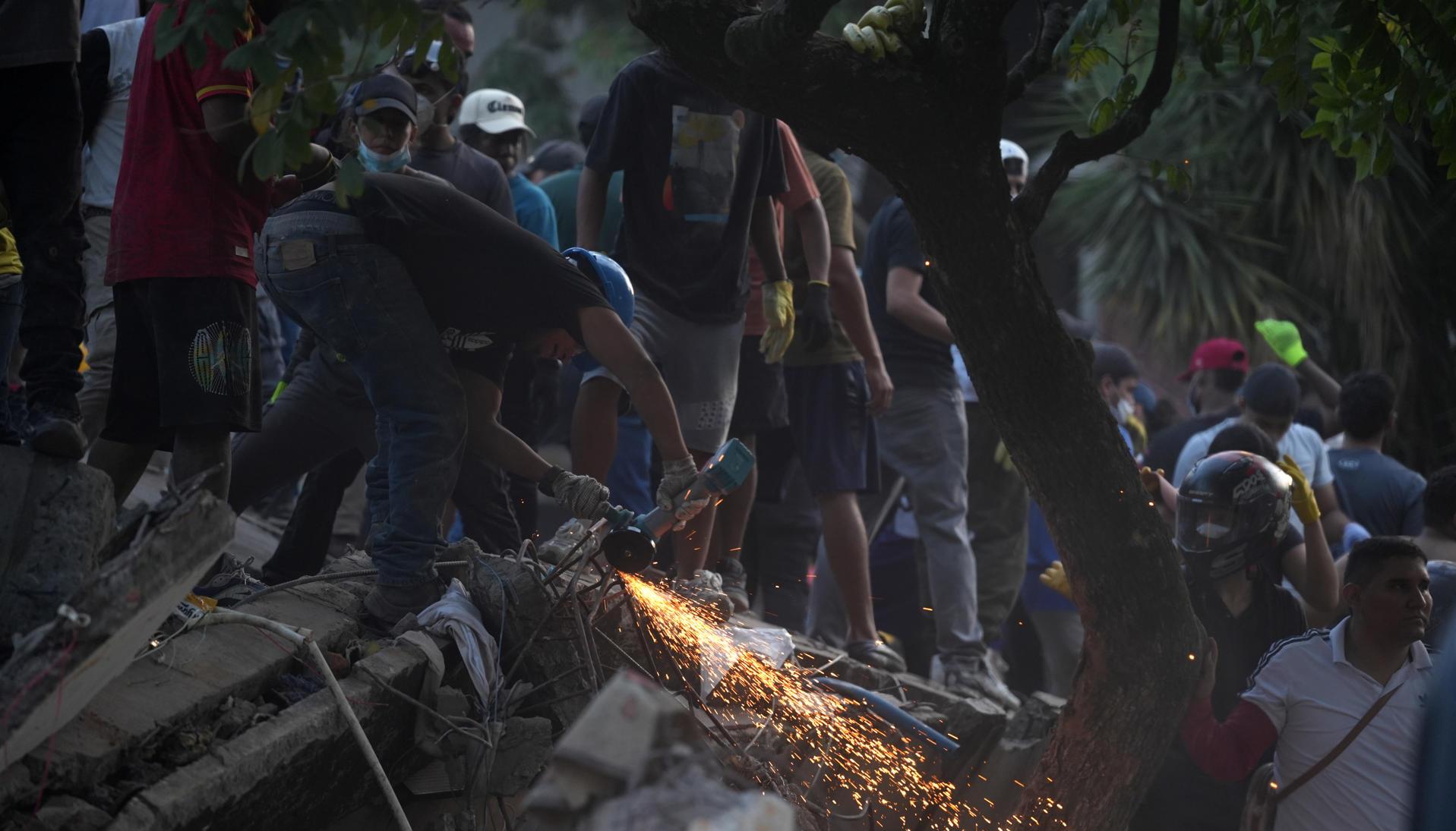 Voluntarios trabajan en labores de rescate en una edificación colapsada 