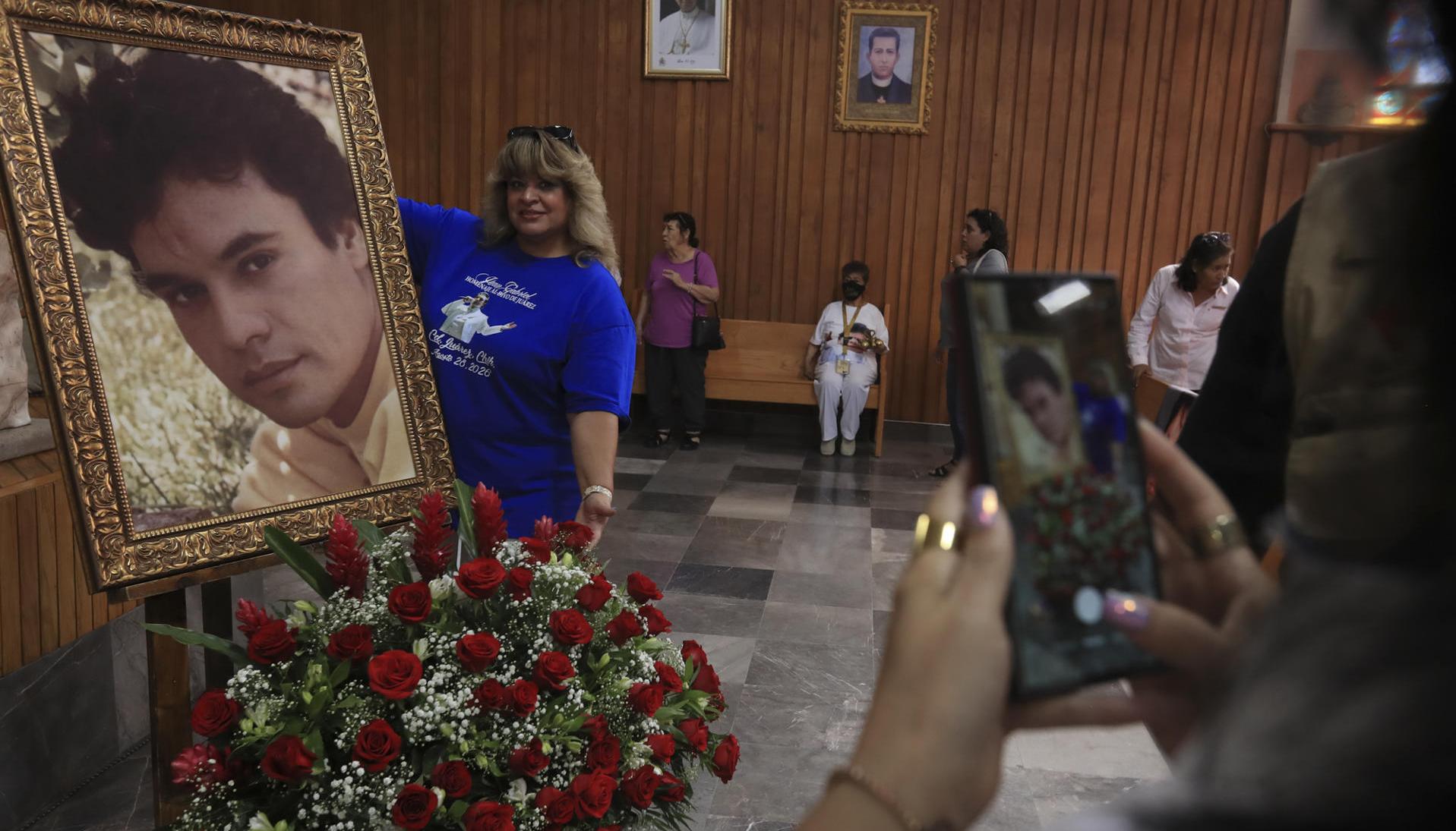 Seguidores de Juan Gabriel el 'Divo de Juárez' posan junto a una fotografía en Ciudad Juárez