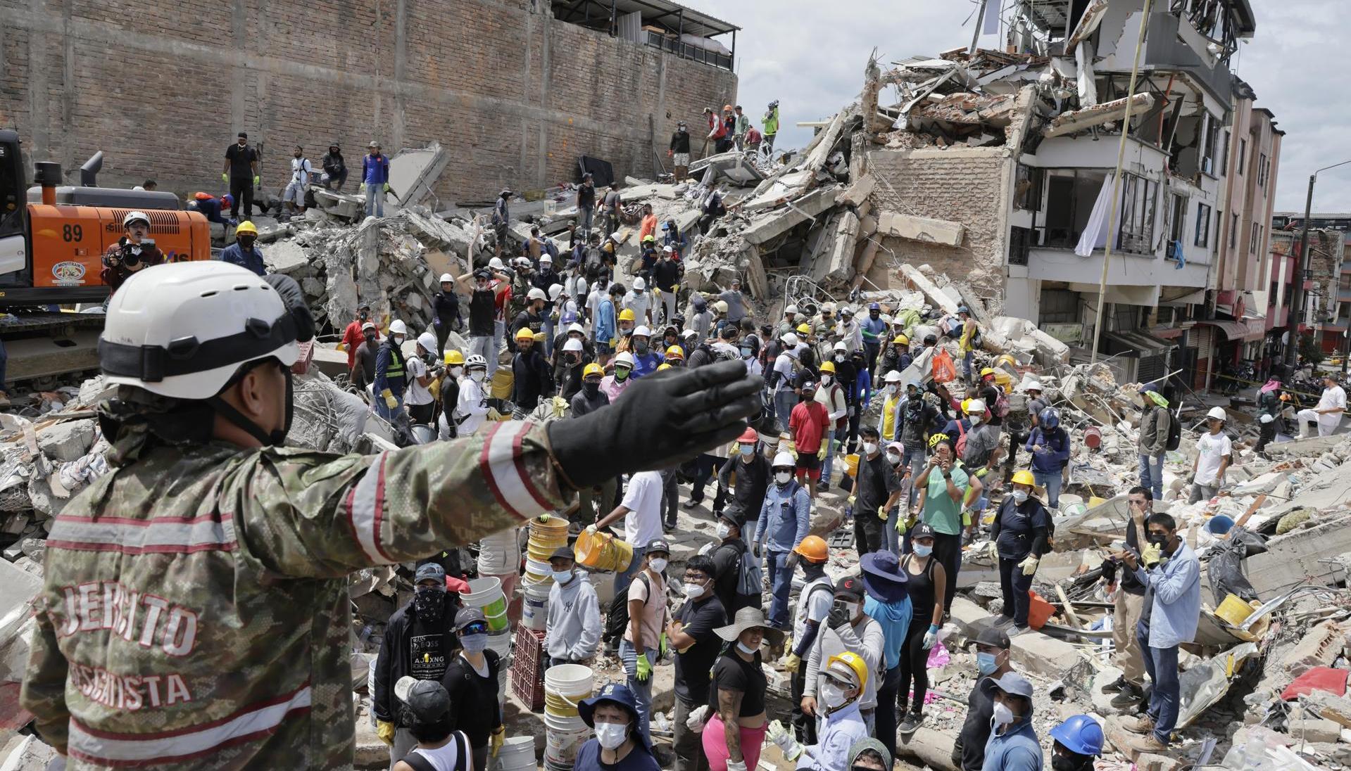 Una rescatista del Ejercito de Colombia da indicaciones a un grupo de voluntarios