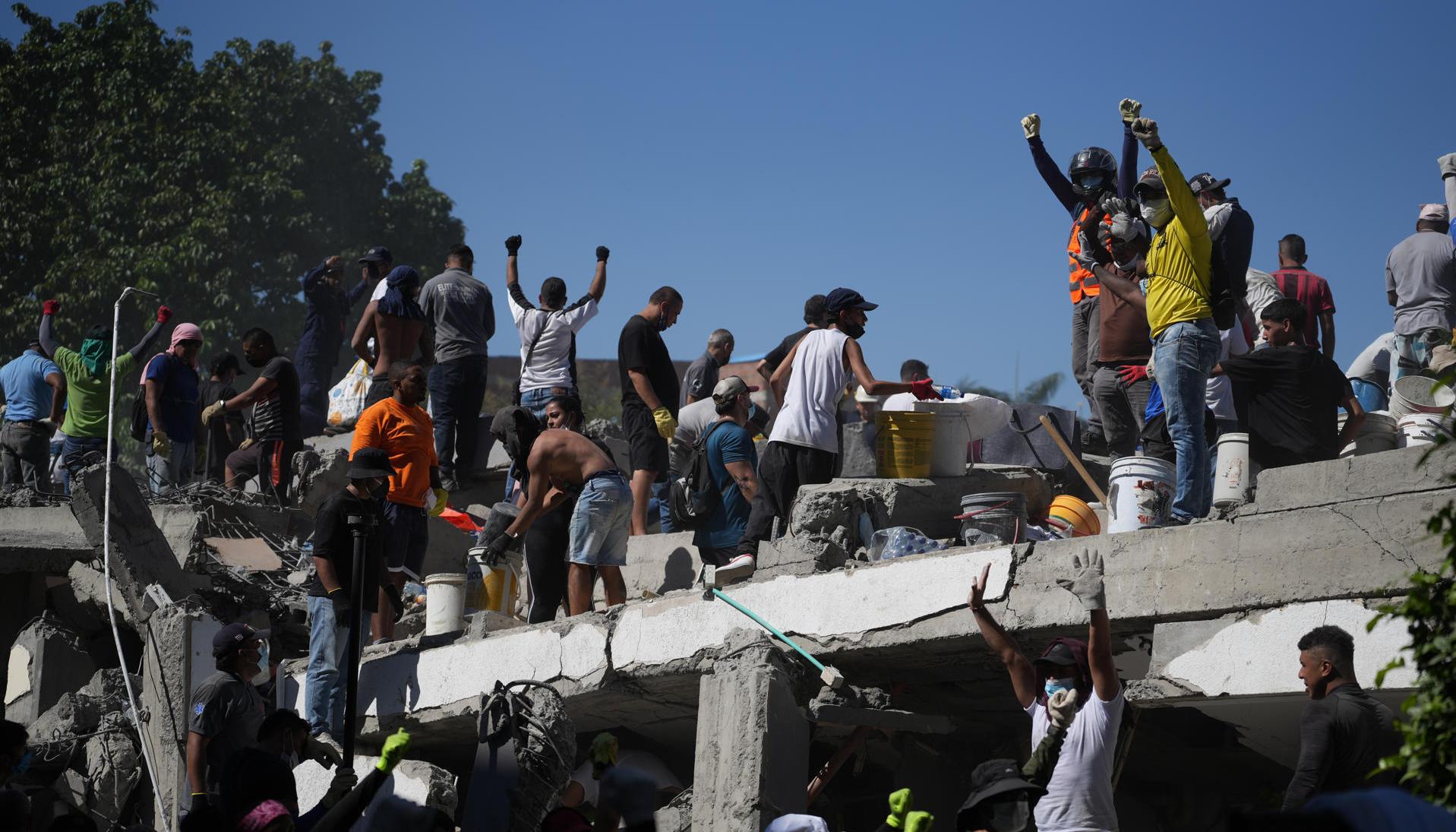 Personas trabajan en labores de rescate en una edificación colapsada en Cali.