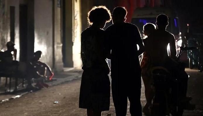 Personas dialogando en una calle de Cuba en medio de un apagón. 