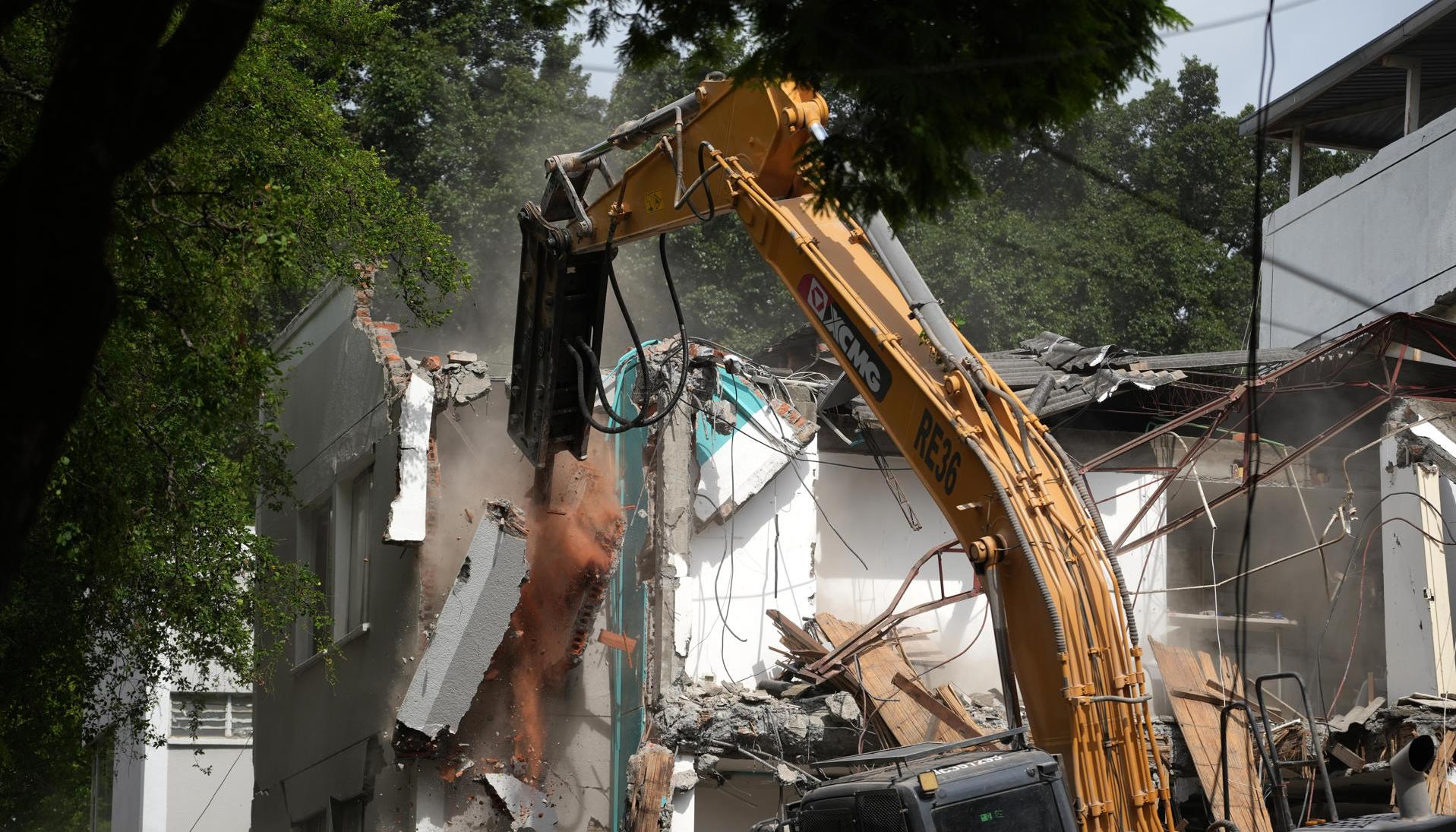 Retroexcavadora demoliendo un edificio.