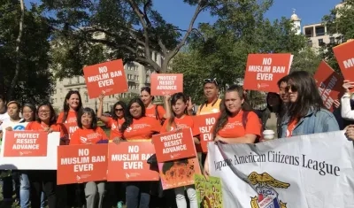  Un centenar de personas se concentró hoy delante de la Casa Blanca para protestar por ambas medidas.