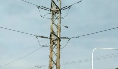 El hombre se sentó en la parte más alta de la torre de energía.