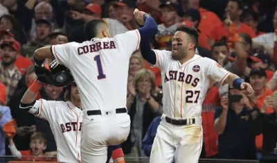 Carlos Correa celebra con José Altuve tras una carrera anotado.