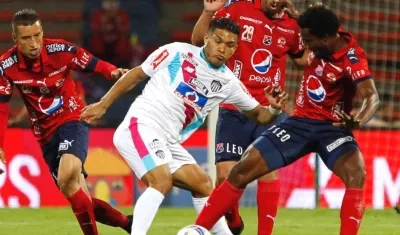 Teófilo Gutiérrez disputa la pelota con defensores del DIM.