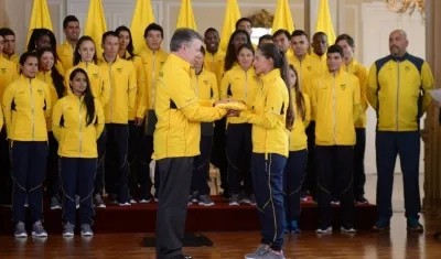 Santos entregando la bandera a Fabriana Arias.