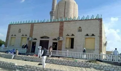 Varias personas permanecen en el exterior de una mezquita contra la que se ha perpetrado un ataque en Egipto.