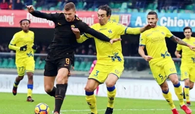 Edin Dzeko protege la pelota de la marca de un rival. 