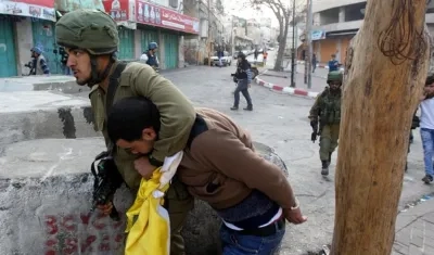 Soldado sometiendo a uno de los manifestantes.