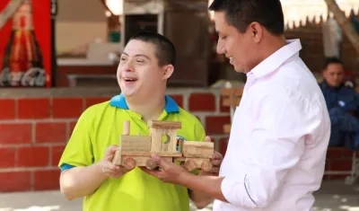 Alegría de un joven con discapacidad al recibir su trencito de madera.