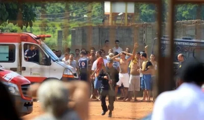 Un grupo de reclusos es custodiado tras la revuelta en la cárcel.