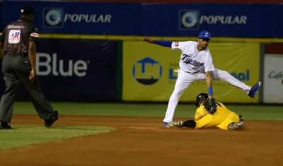 El jugador de Los Tigres del Licey (arriba) Sergio Alcántara, pone out en segunda base a Daniel Santana (abajo) de Las Águilas Cibaeñas.