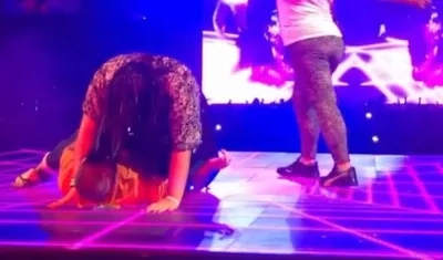 El cantante J Balvin y dos fans en tarima.