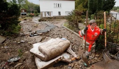 Una voluntaria de la Cruz Roja despeja una calle de escombros tras las inundaciones provocadas por las fuertes lluvias en el departamento de Aude, en Conques (Francia).