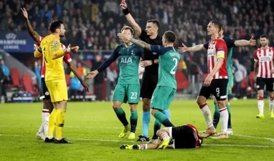 Hugo Lloris (i), portero francés del Tottenham, recibe la tarjeta roja durante el partido disputado ante el PSV correspondiente al grupo B de la Liga de Campeones de la UEFA en Eindhoven, Holanda.