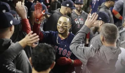 Mookie Betts celebra con sus compañeros el jonrón conectado el sexto episodio.