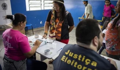  La indígena y pedagoga de la etnia Baré Ana Claudia Martins Tomas (2i), de 40 años, hace su identificación biométrica antes de votar en la comunidad rural de "Nossa Senhora do Livramento", en el Río Negro.