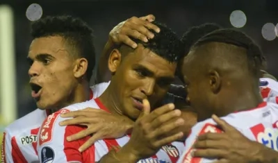 Jugadores de Junior celebran con Rafael Pérez tras su anotación.