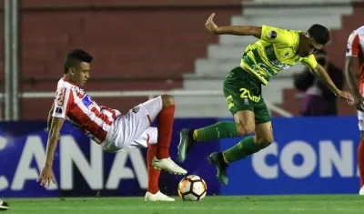 Víctor Cantillo disputa la pelota con un jugador de Defensa y Justicia. 