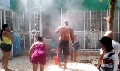 Residentes y vecinos sofocando las llamas con baldes con agua.