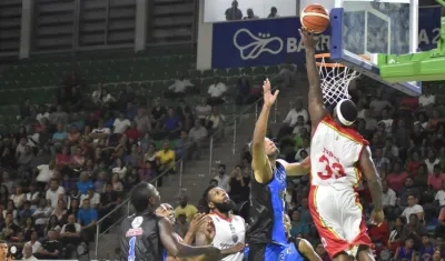 Troy Jones anota bajo la mirada de Michael Sneed. 