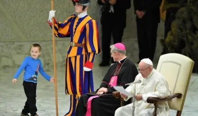 Un niño argentino de unos siete u ocho años accede al escenario del Aula Pablo VI mientras el papa Francisco (d) preside su audiencia general de los miércoles en el Vaticano, 